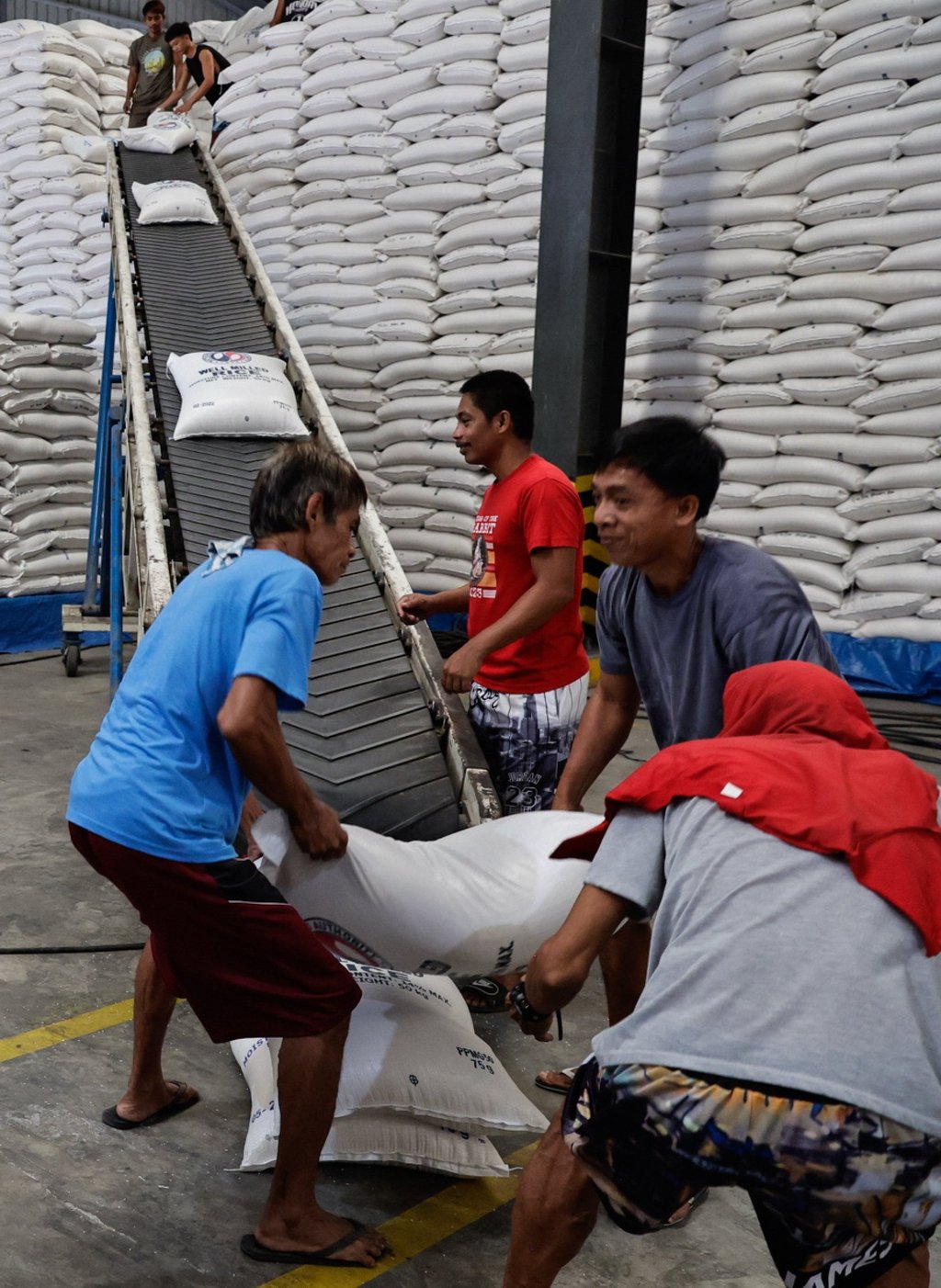 Workers move sacks of rice for transport from a National Food Authority warehouse in Valenzuela City, Metro Manila, Philippines, on February 19 after the Department of Agriculture declared a food security emergency. Photo: EPA-EFE