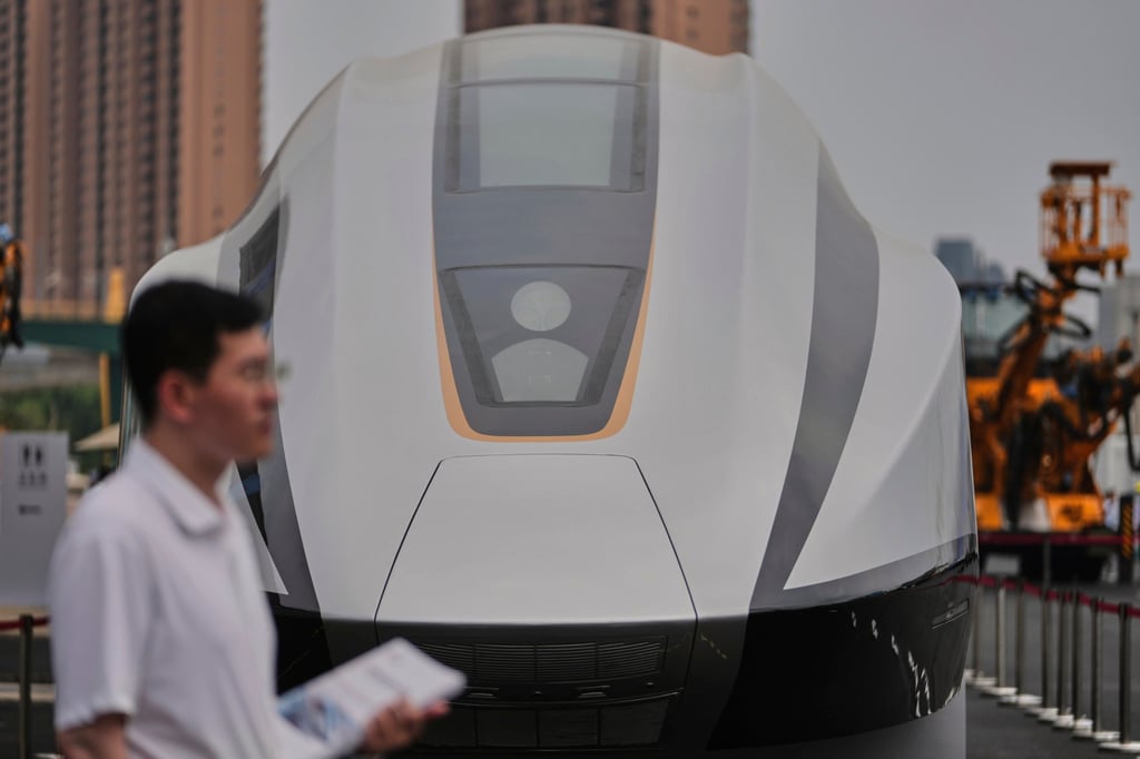 A volunteer holds leaflets as he stands near a 600km/h High Speed Maglev model showcasing at the National Railway Test Center during a tour by delegates to the World Congress on High-Speed Rail held in Beijing, on July 9. Photo: AP