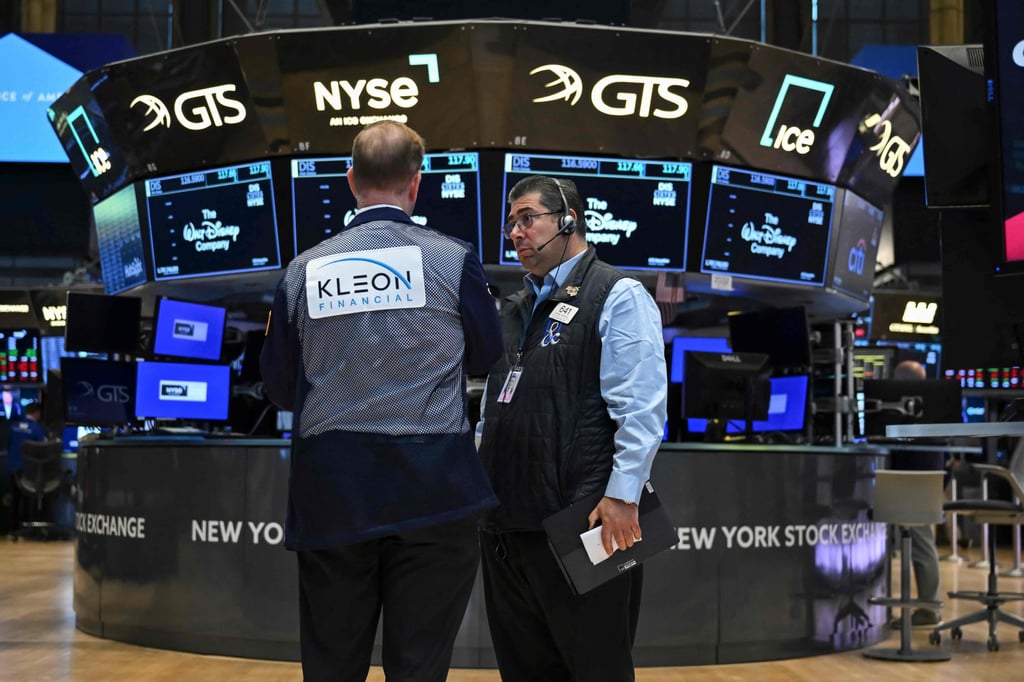 Traders work on the floor of the New York Stock Exchange. Apple again helped lead the market on Thursday amid hopes that its massive size can help it navigate the new economy Trump is trying to fashion. Photo: AFP