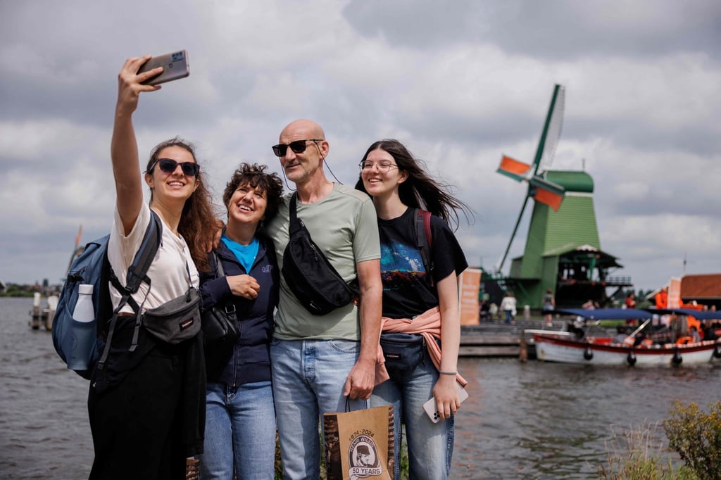 Tourists take selfies in front of a windmill in Zaanse Schans. Photo: AFP