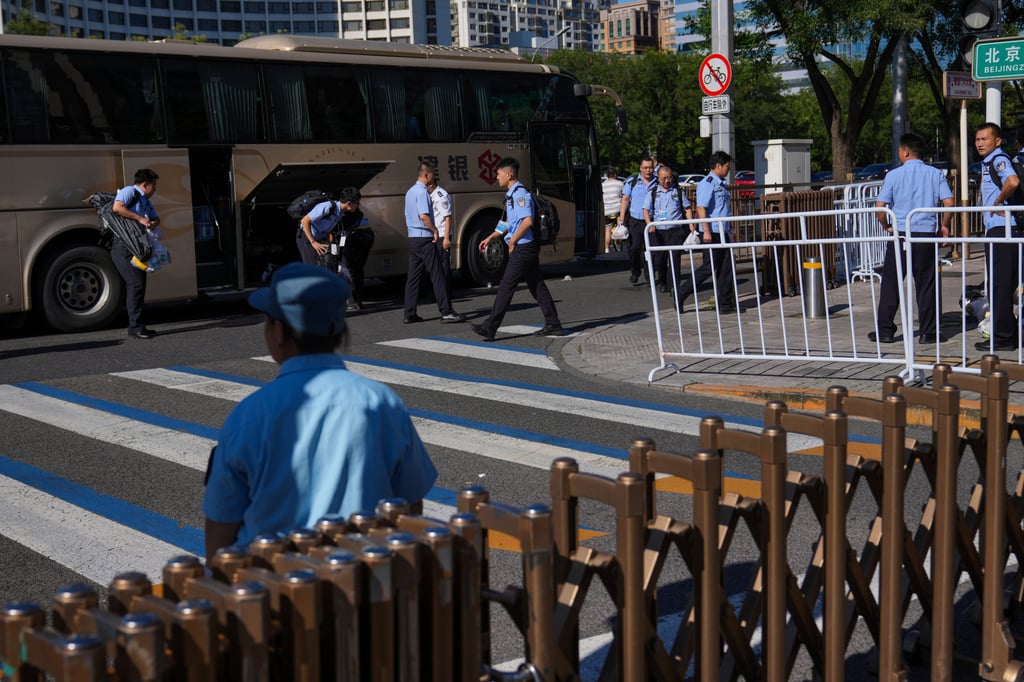 Policemen disembark from a bus in central Beijing on Saturday to prepare for a rehearsal for a military parade next month. Photo: AP Policemen disembark from a bus in central Beijing on Saturday to prepare for a rehearsal for a military parade next month. Photo: AP