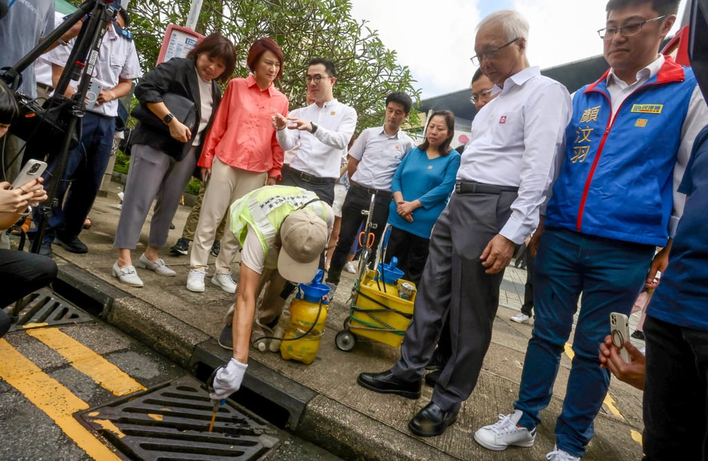 Environment chief Tse Chin-wan (second from right) and lawmaker Starry Lee (red shirt), observe officers conducting anti-mosquito measures at Sau Mau Ping shopping centre on Tuesday. Photo: Jonathan Wong