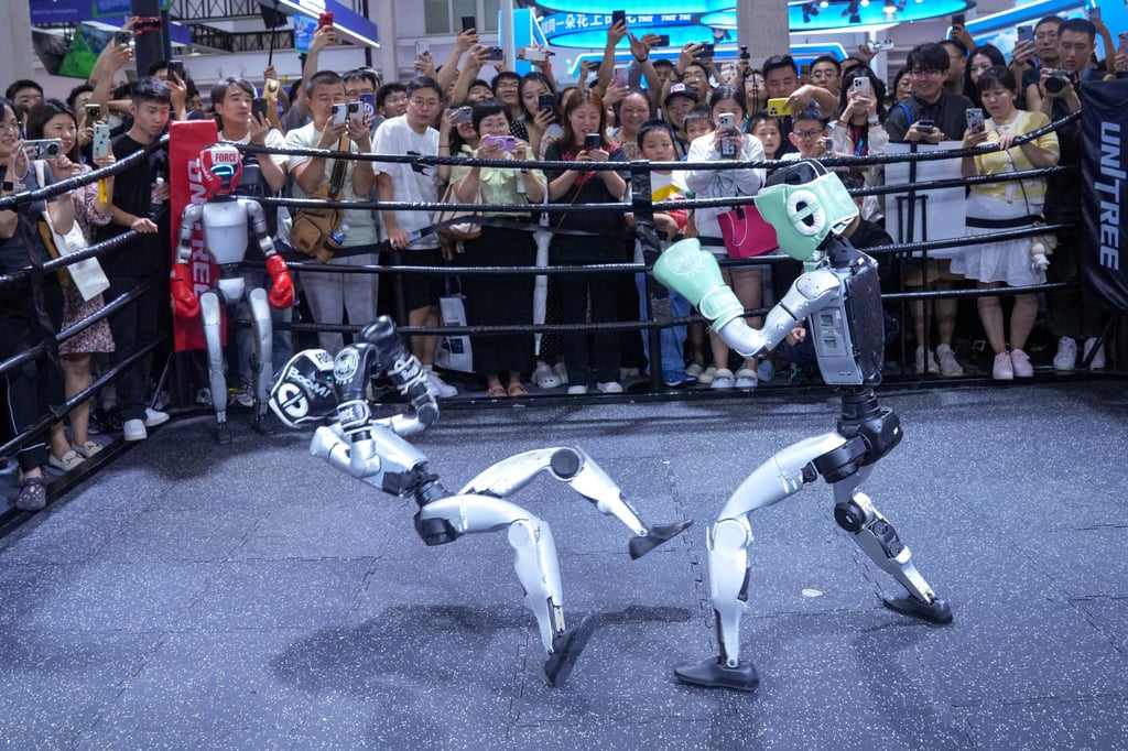 Visitors watch humanoid robots fight at the Unitree booth during the World Robot Conference in Beijing. Photo: cnsphoto via Reuters Visitors watch humanoid robots fight at the Unitree booth during the World Robot Conference in Beijing. Photo: cnsphoto via Reuters