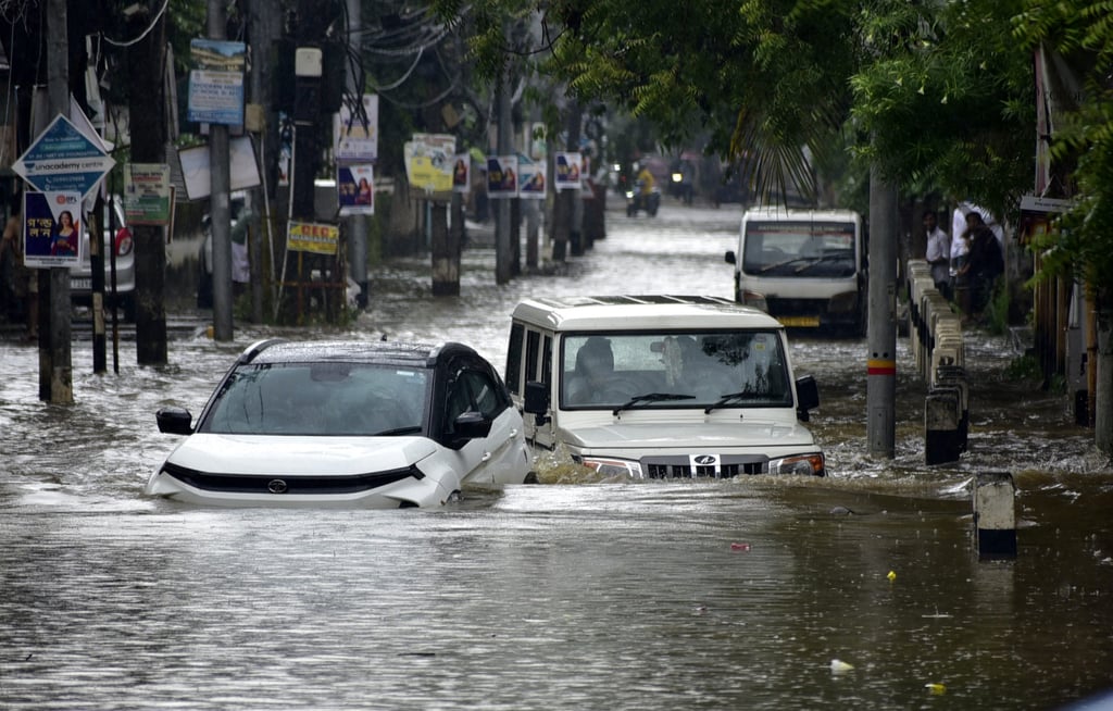 Vehicles wade through the flooded street after rain in Guwahati, Assam. Photo: dpa