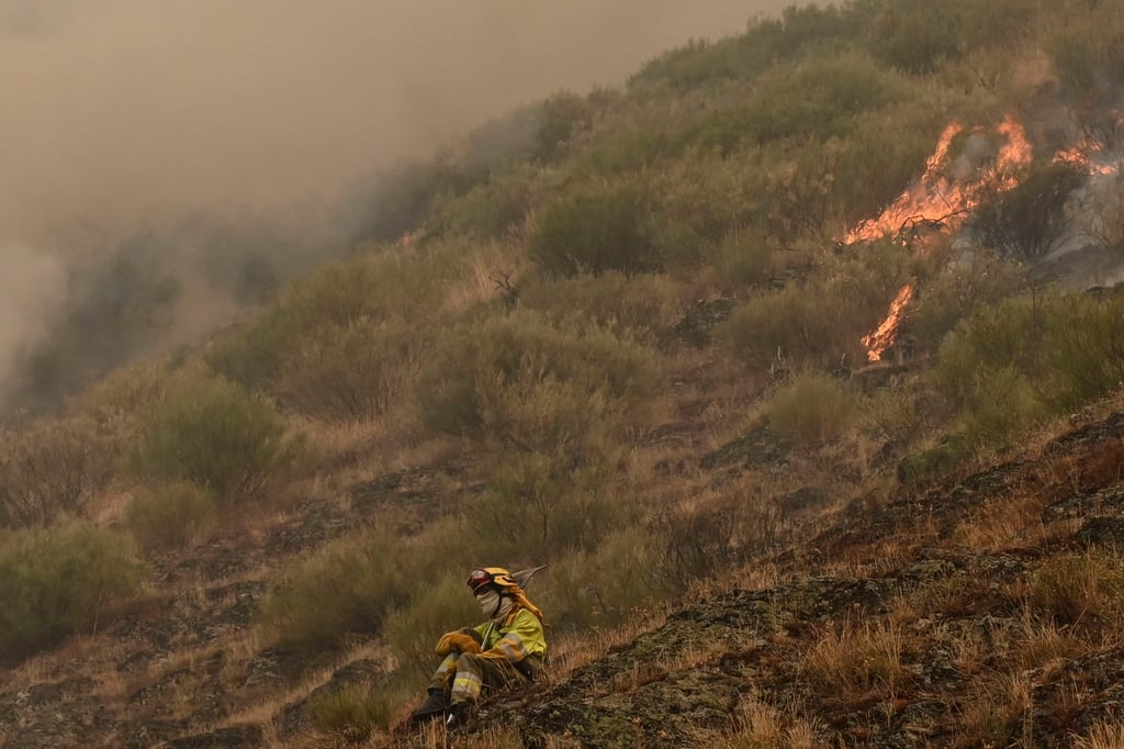 A firefighter rests as flames continue to burn land at Barniedo de la Reina, Leon, Spain, on Monday. Photo: EPA A firefighter rests as flames continue to burn land at Barniedo de la Reina, Leon, Spain, on Monday. Photo: EPA