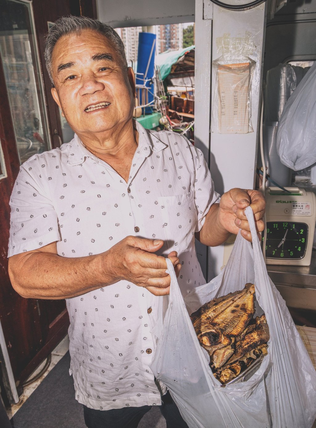 Lam Lau with a bag of dried flounder that he uses to make salted fish broth every day. Photo: Jocelyn Tam