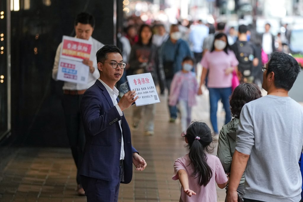 Insurance sales agents approach mainland Chinese tourists on Tsim Sha Tsui’s Canton Road. Photo: Eugene Lee