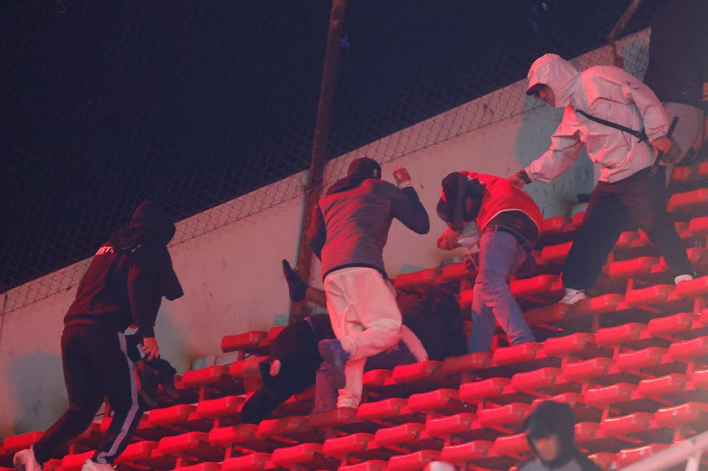 Fans clash in the stands during Independiente’s clash with Universidad de Chile. Photo: EPA Fans clash in the stands during Independiente’s clash with Universidad de Chile. Photo: EPA