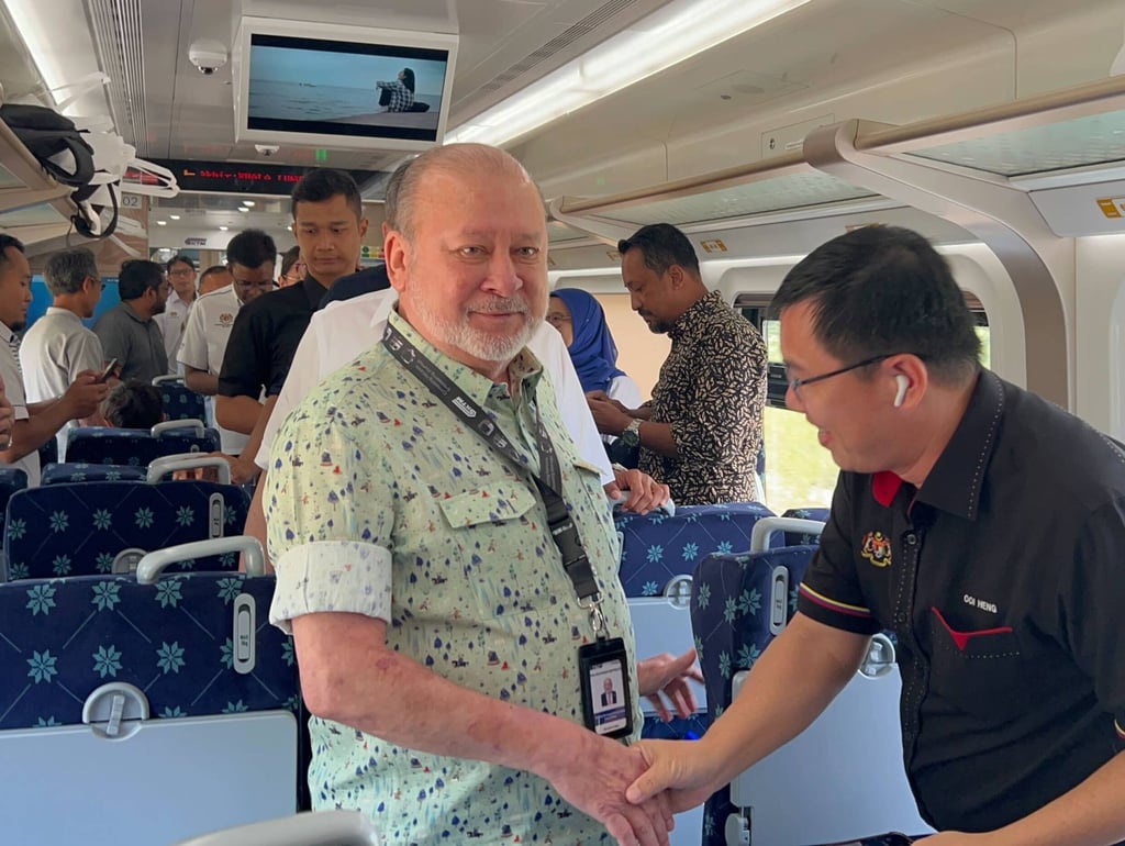 The Malaysian king greets officials and passengers on board the ETS. Photo: Hadi Azmi The Malaysian king greets officials and passengers on board the ETS. Photo: Hadi Azmi