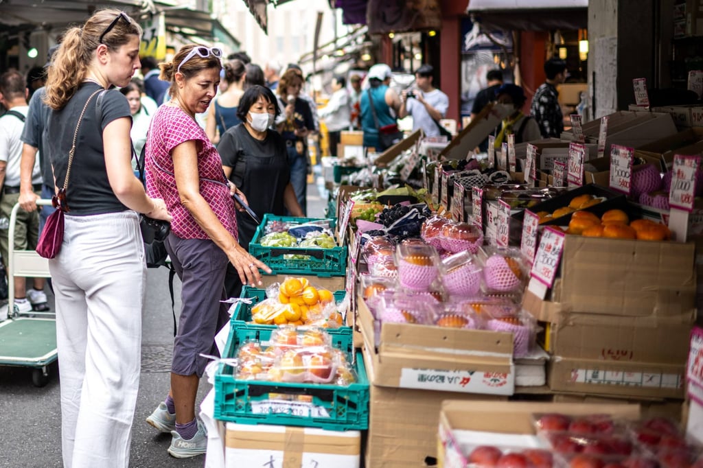 Tourists look at the fruit for sale at a market in Tokyo on Friday. Photo: AFP Tourists look at the fruit for sale at a market in Tokyo on Friday. Photo: AFP