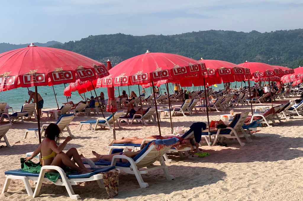 Tourists lounge under umbrellas along Patong Beach in Phuket. Local authorities have launched public awareness campaigns to urge tourists to obey warnings and swim only in patrolled areas. Photo: AP Tourists lounge under umbrellas along Patong Beach in Phuket. Local authorities have launched public awareness campaigns to urge tourists to obey warnings and swim only in patrolled areas. Photo: AP