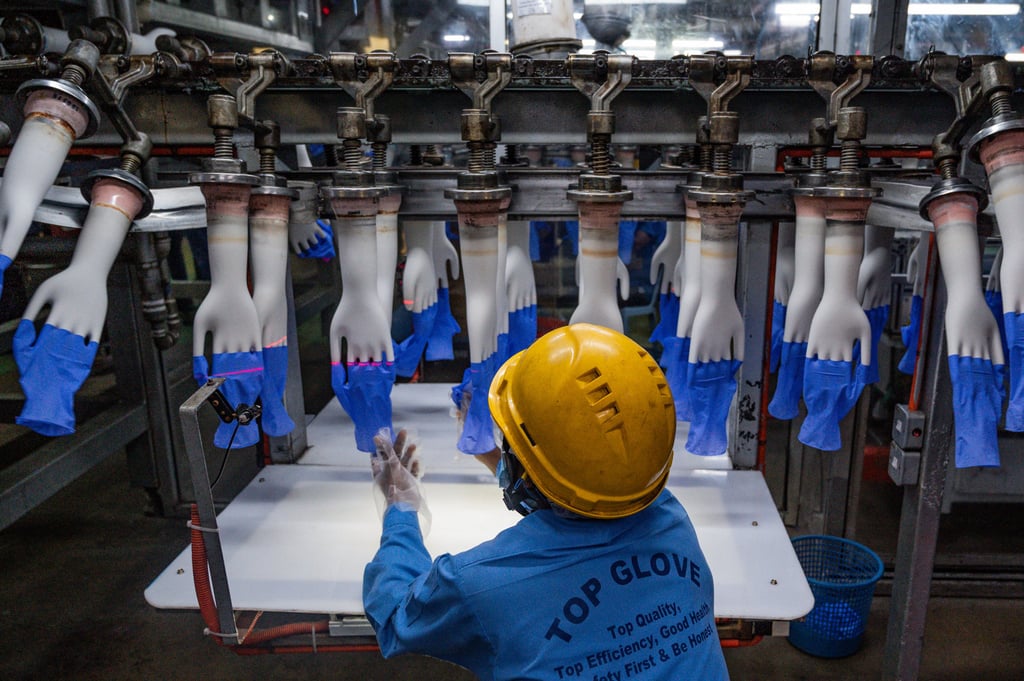 A worker inspects disposable gloves at the Top Glove factory on the outskirts of Kuala Lumpur. Lau’s family fortune is tied to the world’s largest rubber glove manufacturer. Photo: AFP A worker inspects disposable gloves at the Top Glove factory on the outskirts of Kuala Lumpur. Lau’s family fortune is tied to the world’s largest rubber glove manufacturer. Photo: AFP