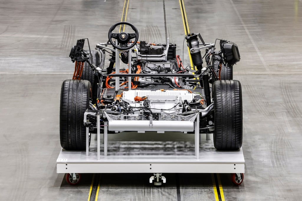 A stripped-down Porsche EV chassis shows the integrated high-voltage battery, drivetrain and power electronics, optimised for durability and crash protection. Photo: Porsche