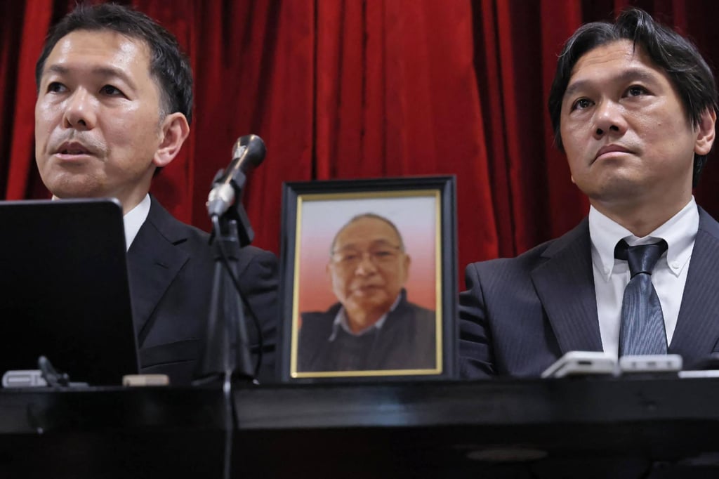 A portrait of the late Shizuo Aishima is displayed between his sons during a press conference in Yokohama on Monday. Photo: AFP A portrait of the late Shizuo Aishima is displayed between his sons during a press conference in Yokohama on Monday. Photo: AFP
