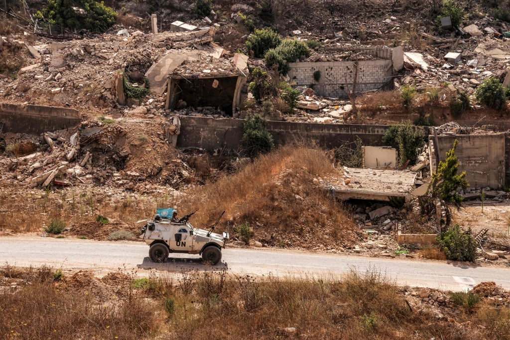 An armoured UN vehicle drives past destroyed buildings along a road in the village of Kfar Kila in southern Lebanon near the border with northern Israel. Photo: AFP