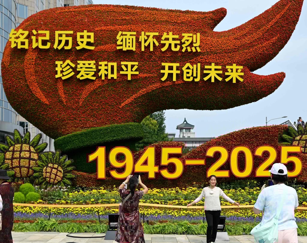 People take pictures in front of a floral installation in Beijing commemorating the 80th anniversary of victory over Japan on August 18. Photo: AFP