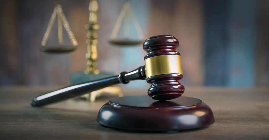 A judge’s gavel is pictured, with the scales of justice in the background. The suspects in the case were ordered to surrender their passports and stay away from the victims. Photo: Shutterstock A judge’s gavel is pictured, with the scales of justice in the background. The suspects in the case were ordered to surrender their passports and stay away from the victims. Photo: Shutterstock