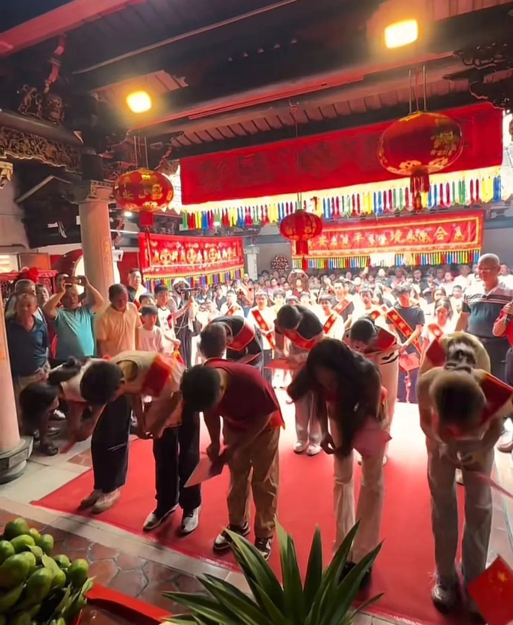 During the ceremony, the successful graduates, adorned in red sashes that read “The glory of our ancestral clan,” paid their respects by bowing before the memorial tablets of their ancestors. Photo: Jimu During the ceremony, the successful graduates, adorned in red sashes that read “The glory of our ancestral clan,” paid their respects by bowing before the memorial tablets of their ancestors. Photo: Jimu