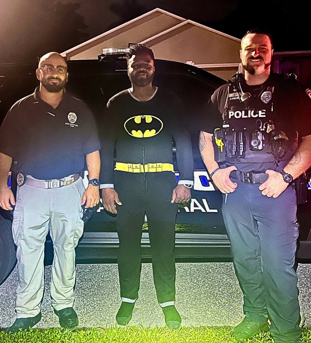Cape Coral man Kyle Myvett (centre) poses for a photo with police officers after helping to catch an early morning burglar in Florida on Wednesday. Photo: Facebook/CapePD