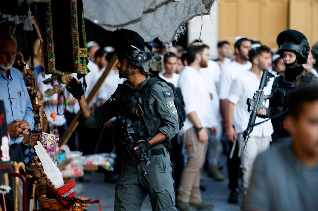 An Israeli border police officer orders a Palestinian shopkeeper to go inside his shop during a weekly settlers’ tour in Hebron, in the Israeli-occupied West Bank on Saturday. Photo: Reuters