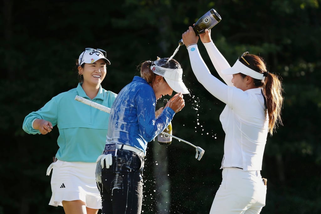 Compatriots Zhang Weiwei (right) and Rose Zhang (left) douse Miranda Wang with champagne. Photo: AP