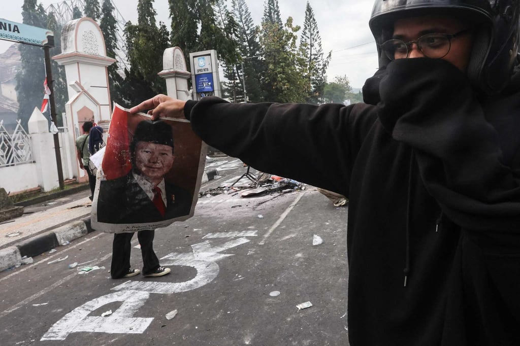 A protester holds a portrait of Indonesian President Prabowo Subianto at a protest on Lombok Island, West Nusa Tenggara, on Saturday. Photo: AFP
