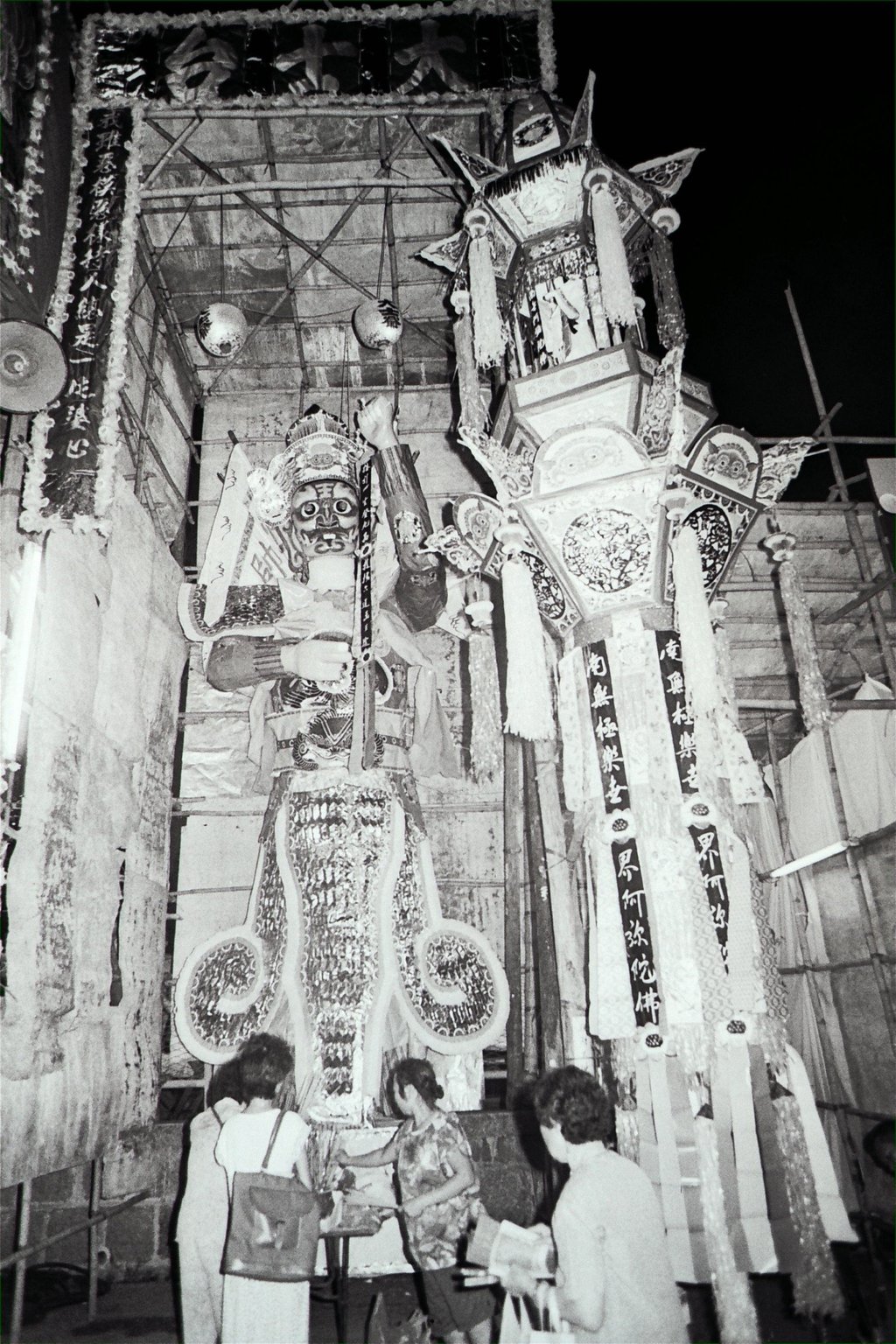 A paper effigy towers over locals in Hung Hom during the Hungry Ghost Festival in 1987. The Chinese believe that spirits not consoled by ancestral worship may claim living substitutes unless they are pacified by food. Photo: SCMP Archives
