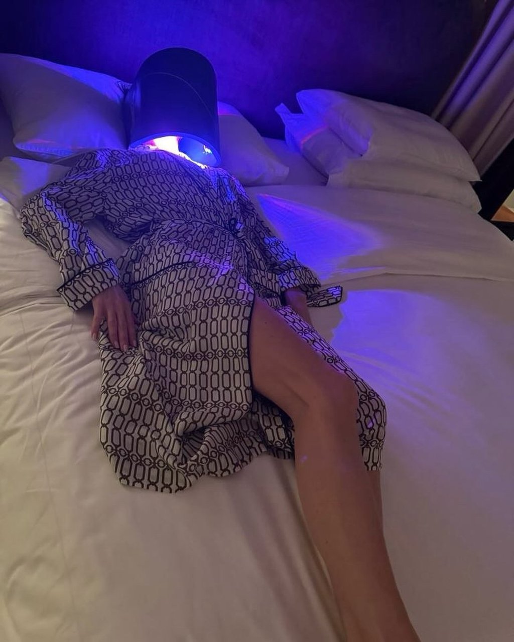 Victoria Beckham lies on a bed with a light-emitting shield over her face in a photograph for an Instagram post. Photo: Instagram/victoriabeckham