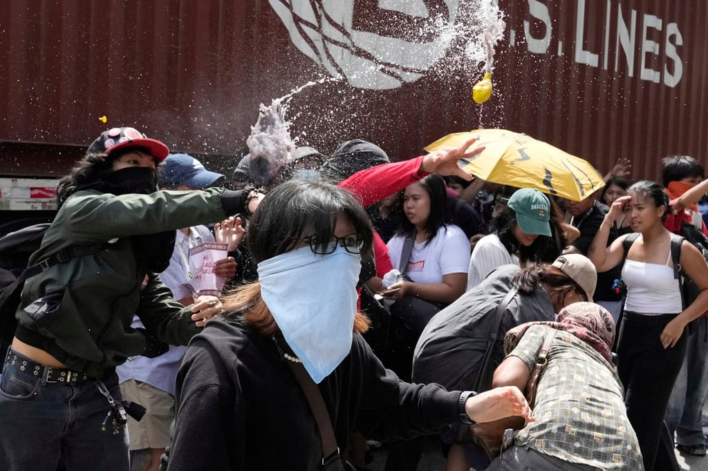 Protesters throw balloons filled with dirty water during a rally on Thursday outside the Philippines’ Department of Public Works and Highways. Photo: AP Protesters throw balloons filled with dirty water during a rally on Thursday outside the Philippines’ Department of Public Works and Highways. Photo: AP