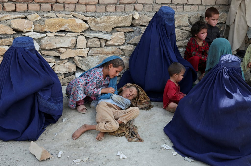 A girl takes care of her brother. Photo: Reuters A girl takes care of her brother. Photo: Reuters