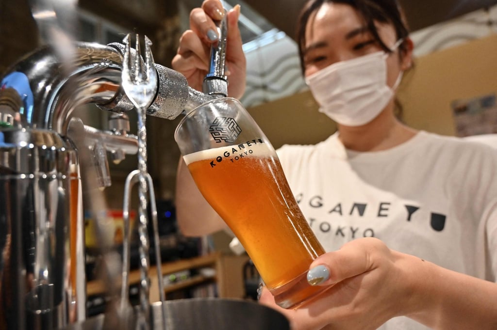An employee pouring a craft beer at a bar in Tokyo. Photo: AFP