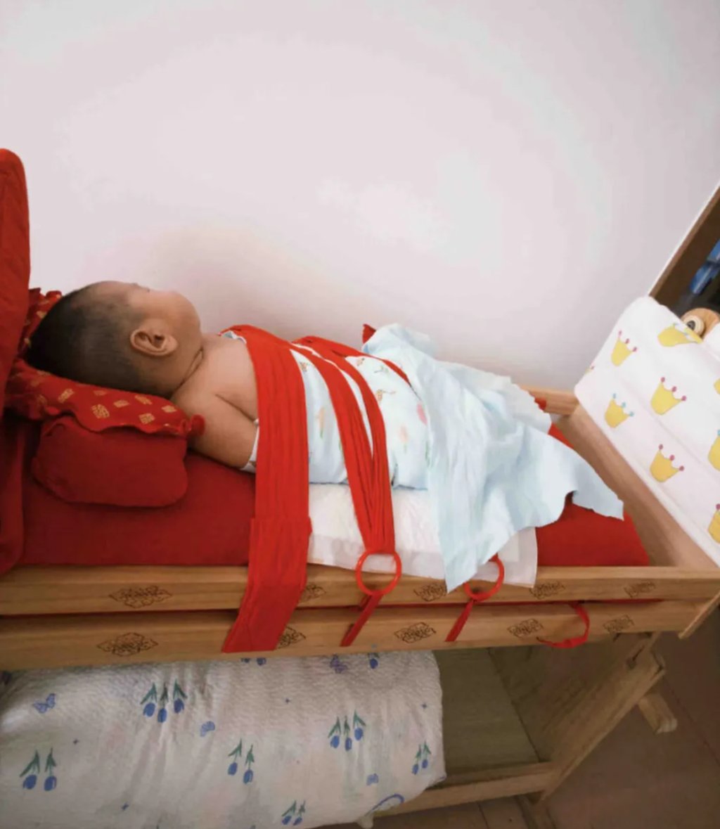 An infant is wrapped up for a nap in one of the “mother’s embrace” cradles. Photo: QQ.com