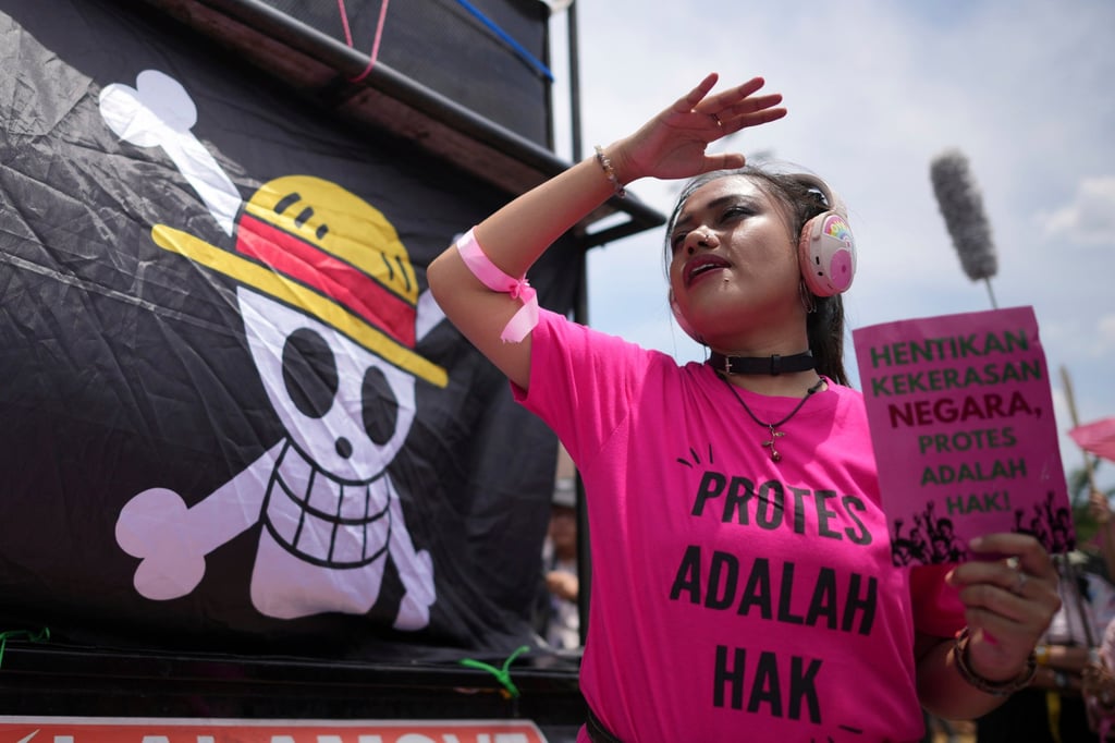 An activist holds a poster as a flag from the Japanese anime One Piece is displayed during a rally in Jakarta, Indonesia, on September 3, 2025. Photo: AP