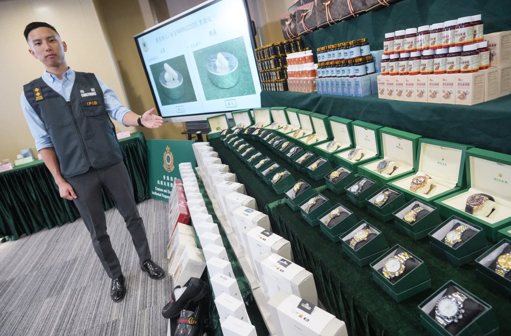 Senior Inspector Hong Yan of the Hong Kong Customs and Excise Department stands beside the bogus goods confiscated in the operation. Photo: May Tse