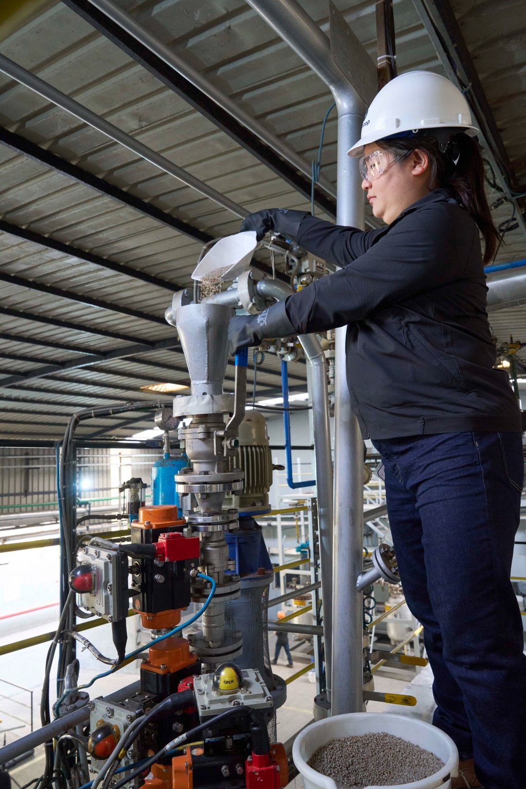 Miranda Wang loads plastic waste pellets, created from upcycling plastic bags and cling film, into a machine at Novoloop’s demonstration plant in Surat, which can be used to create new high-quality plastic products. Photo: Rolex/Greg White