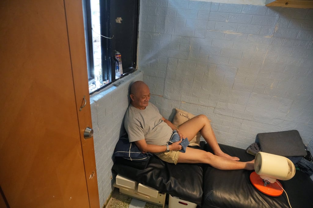 Samuel Wong uses a fan to cool himself down while resting in his subdivided flat. Photo: May Tse Samuel Wong uses a fan to cool himself down while resting in his subdivided flat. Photo: May Tse