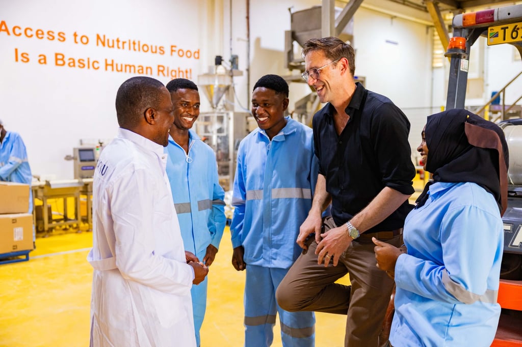 Felix Brooks-church (second right) speaks with workers at Sanku’s nutrient premix blending factory in Dar es Salaam, Tanzania. Photo: Rolex/Peter Ndung’u