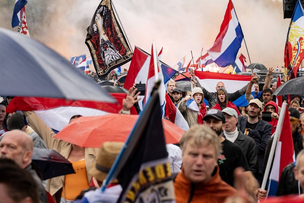 Protesters wave the Dutch national flag as they take part in a demonstration in The Hague on Saturday. Photo: AFP