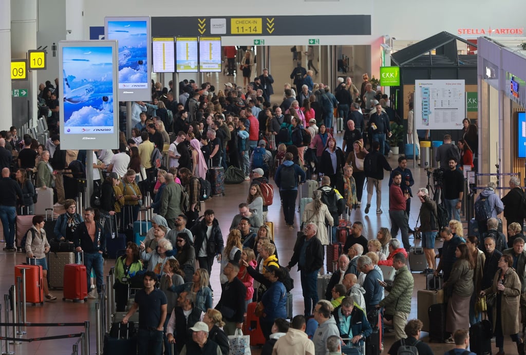 Passengers queue in line at Brussels Airport where dozens of flights were cancelled on Sunday. Photo: EPA