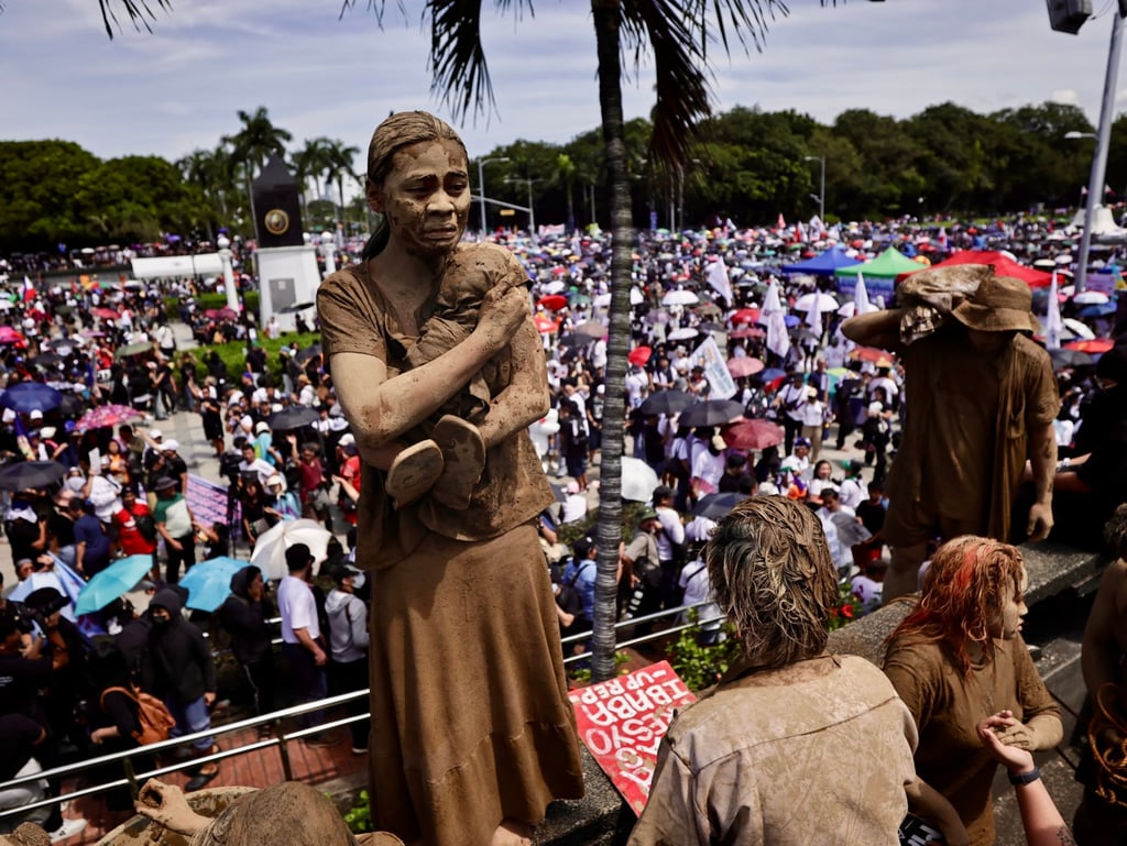 Protesters covered in mud at a rally in Manila on Sunday. Photo: EPA