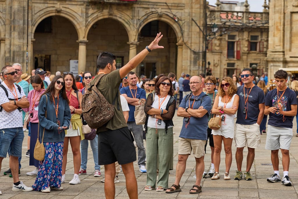People listen to a tour guide near the cathedral in Santiago de Compostela, northwestern Spain. Photo: AP