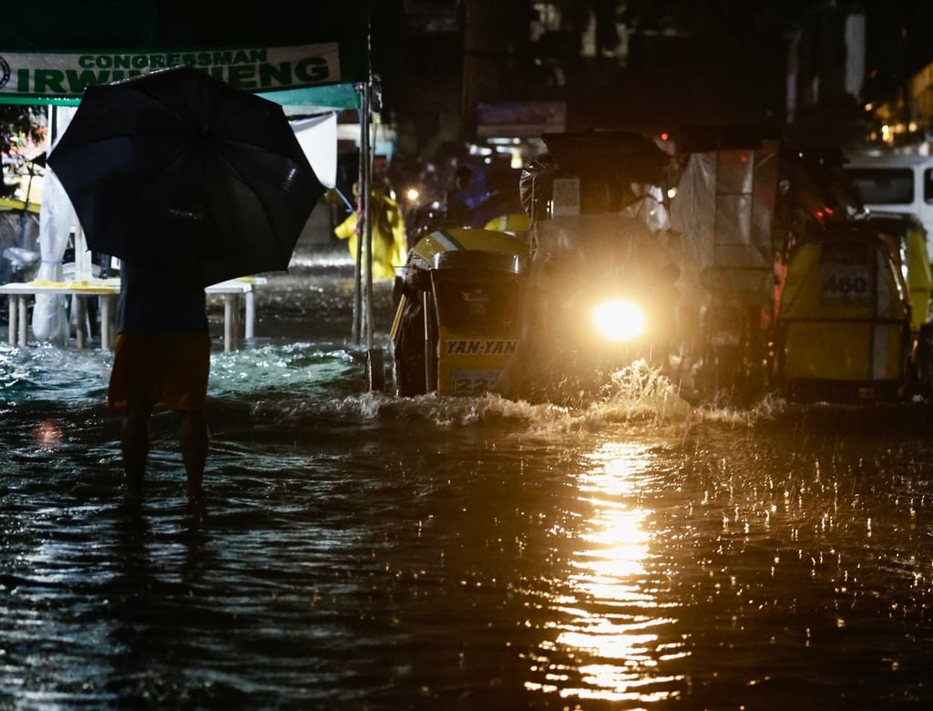 Filipinos wade through floodwaters on a flooded road in Manila on Monday. Photo: EPA