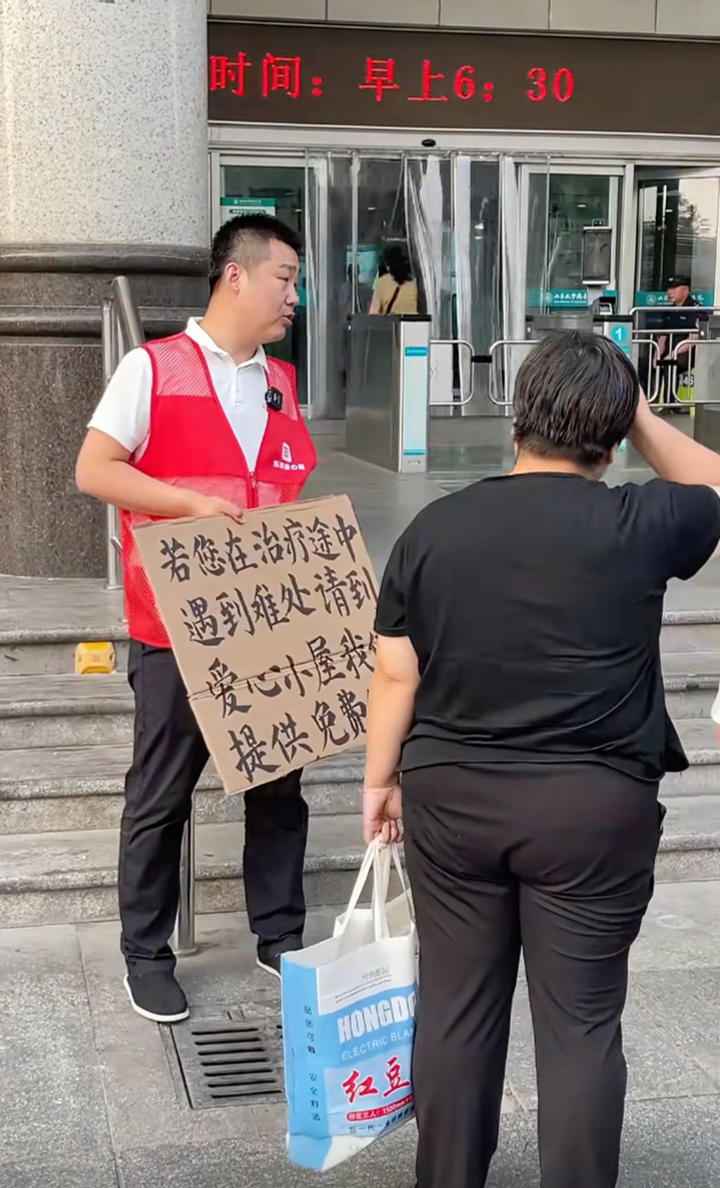 Zheng Gang greets relatives of patients outside the hospital to let them know about his service. Photo: Handout