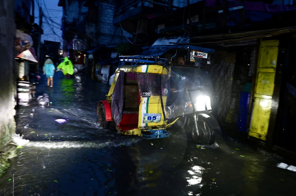 A man rides a pedicab through floodwaters in Manila on Monday. Photo: EPA
