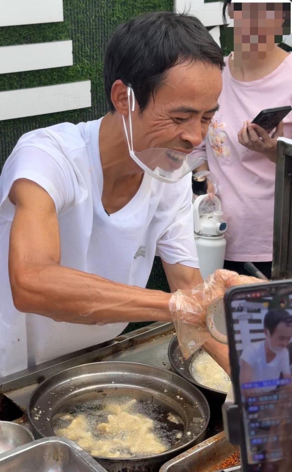 Li Junyong hard a work cooking up a storm at his stall with his trademark smile. Photo: Handout