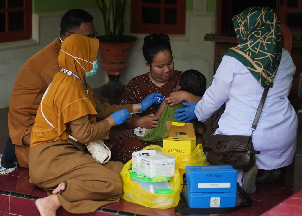 Health workers administer a measles vaccine to a child during a house-to-house campaign in Sumenep on September 8. Photo: AP