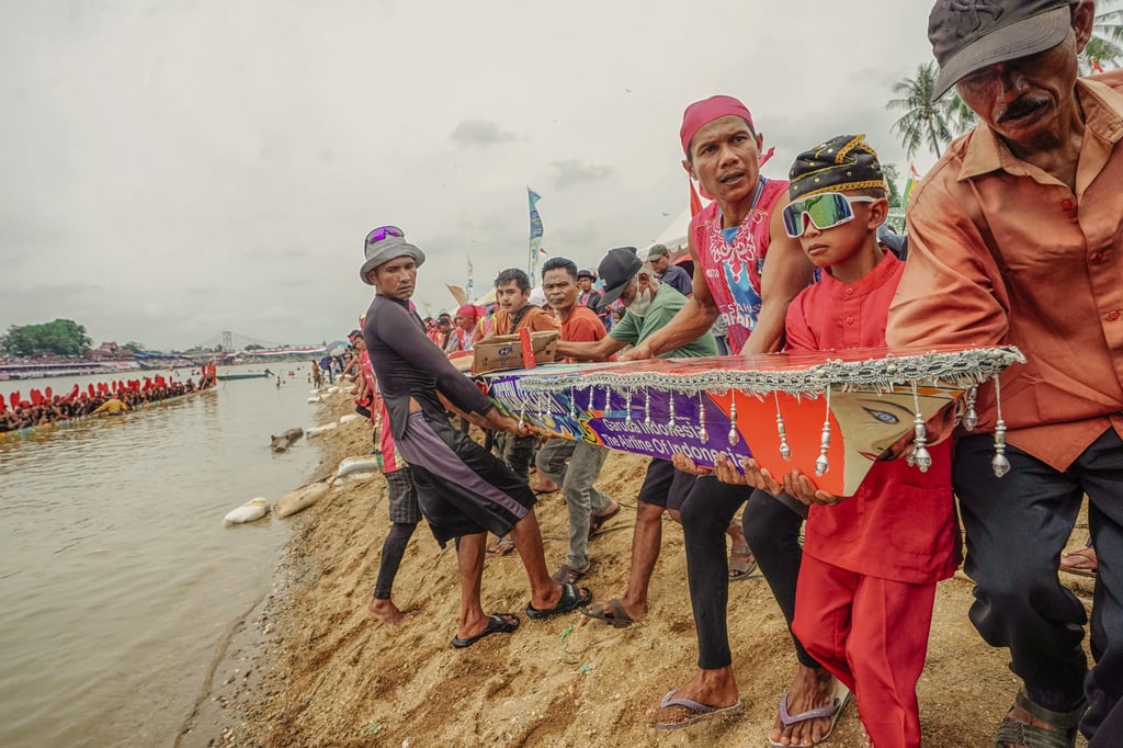 The Pacu Jalur team Sang Ratu Helmina works together to take their traditional longboat to the Kuantan River before the race begins. Photo: Afrianto Silalahi The Pacu Jalur team Sang Ratu Helmina works together to take their traditional longboat to the Kuantan River before the race begins. Photo: Afrianto Silalahi