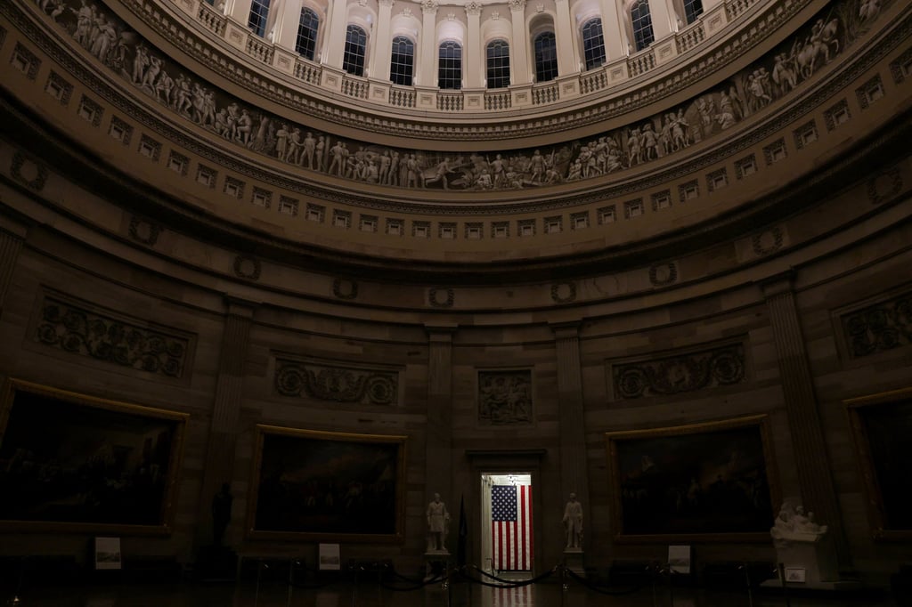 A US flag illuminated in a doorway of the otherwise empty rotunda at the US Capitol. Photo: Reuters