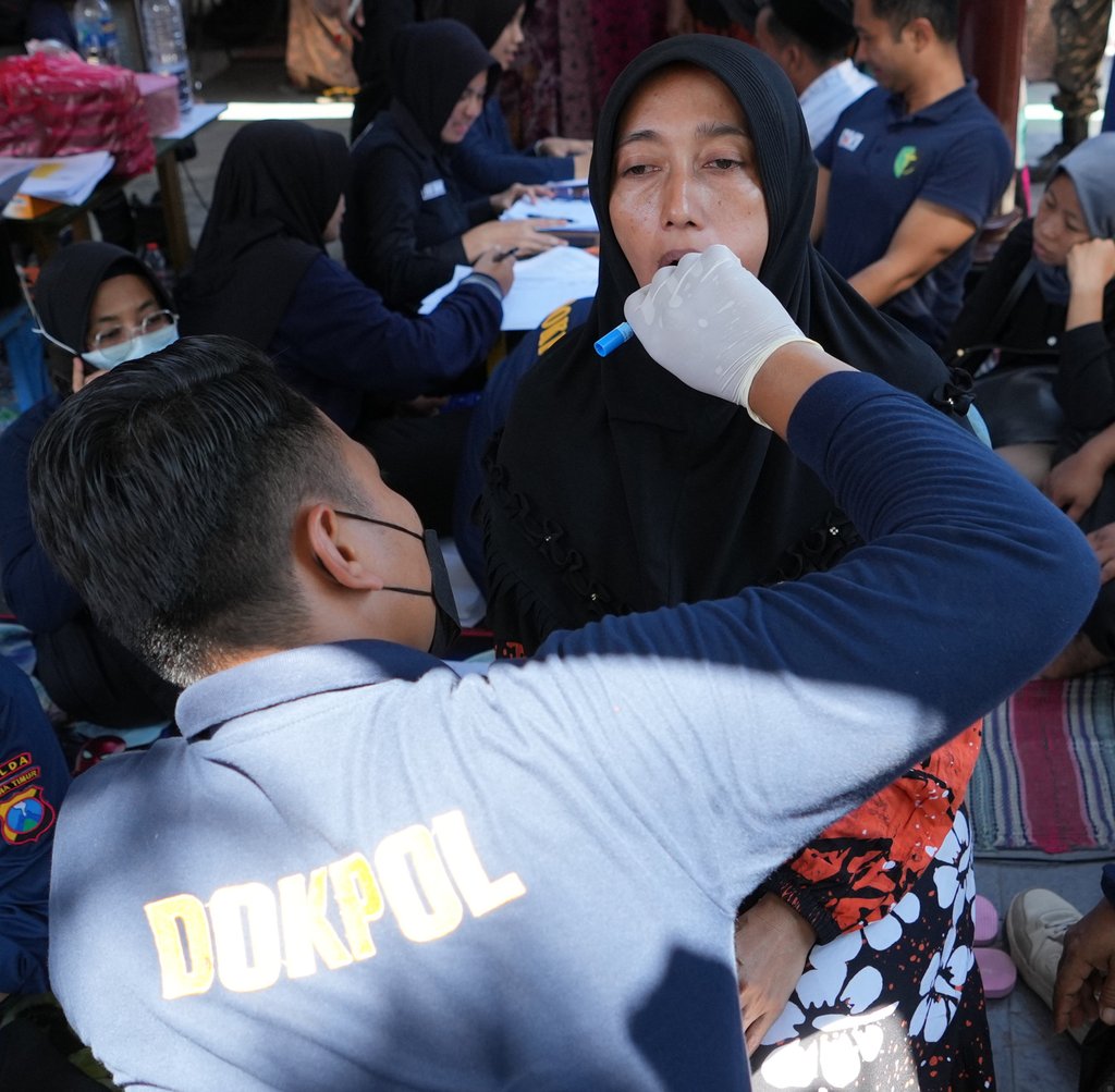 A member of the police forensic unit collects a DNA sample from a student’s family member for victim identification on Thursday. Photo: AP A member of the police forensic unit collects a DNA sample from a student’s family member for victim identification on Thursday. Photo: AP