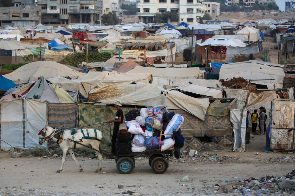 A displaced Palestinian man drives a horse-drawn cart past tents at a refugee camp in the central Gaza Strip on September 22. Photo: AFP
